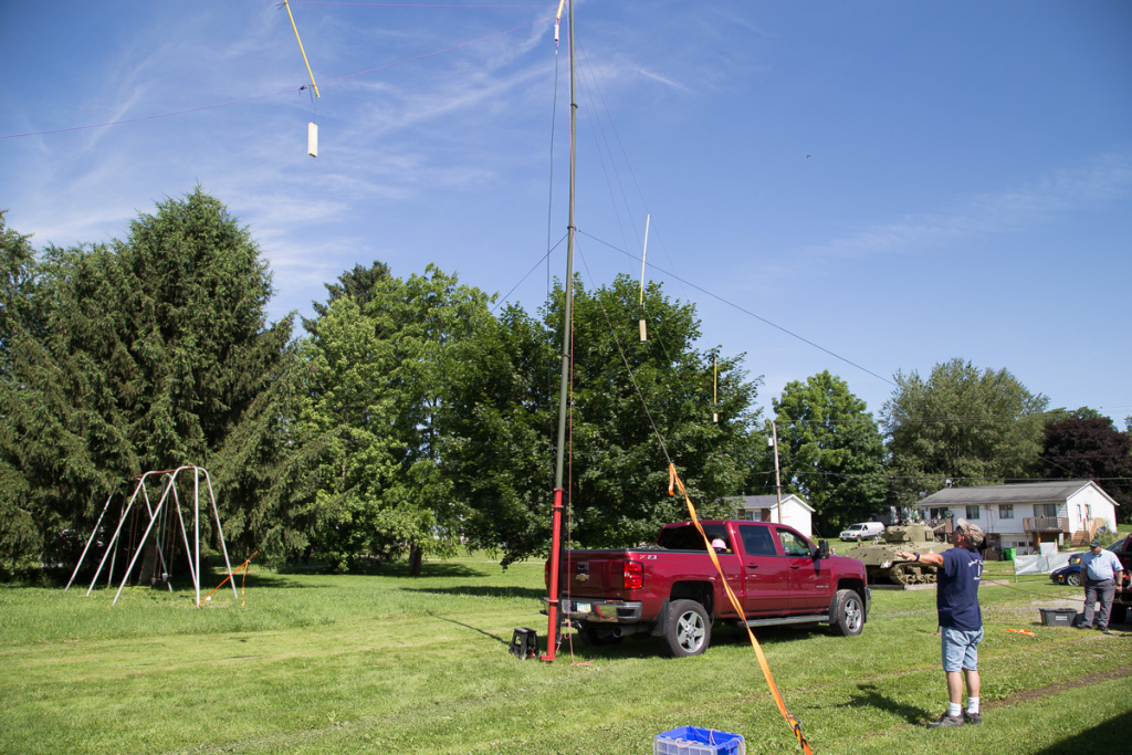 An antenna and antenna mast mounted on the back of a truck.